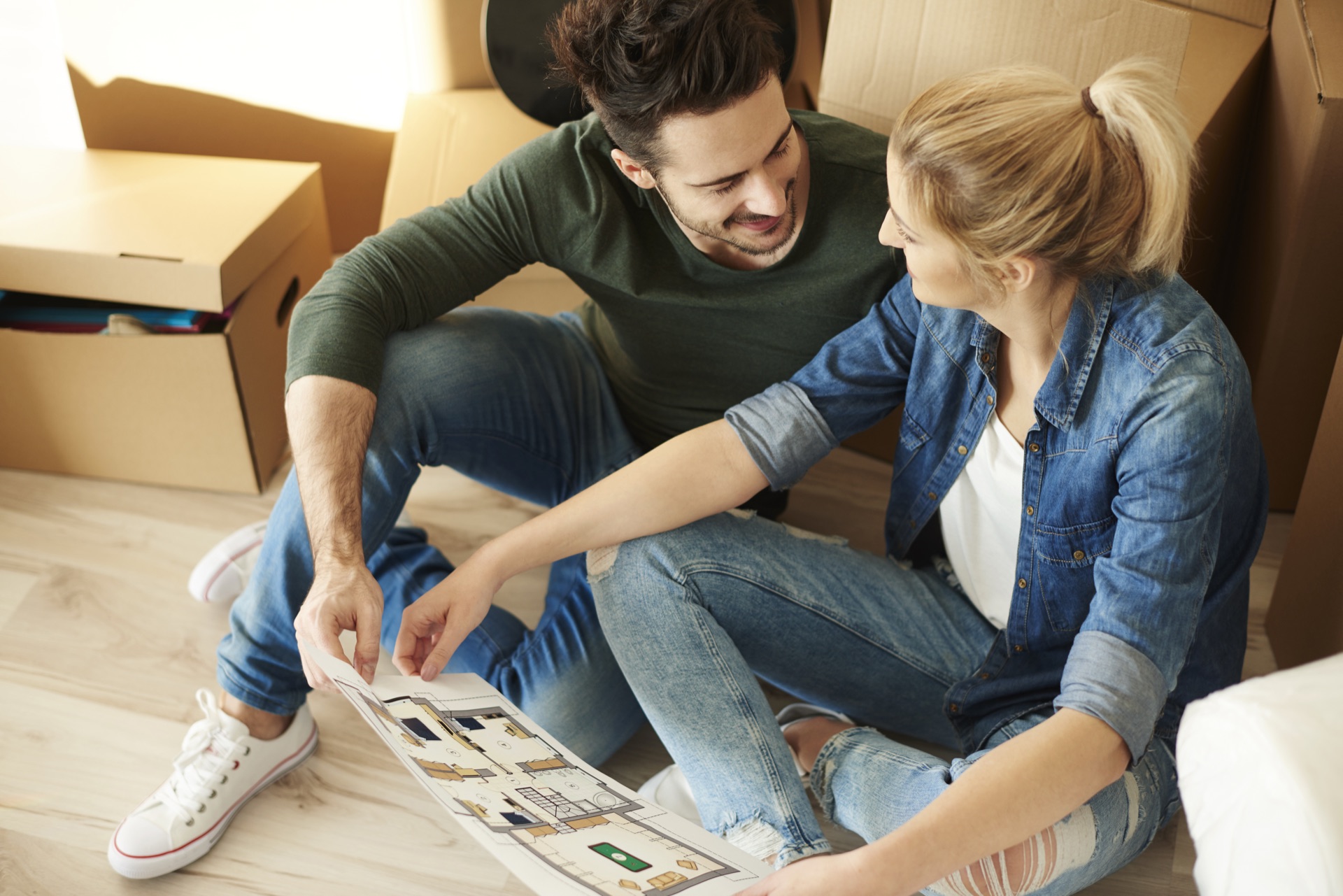 Couple étudiant un plan de logement neuf